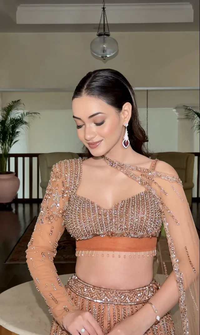 Bride in a peach and rose gold outfit with delicate diamond jewellery